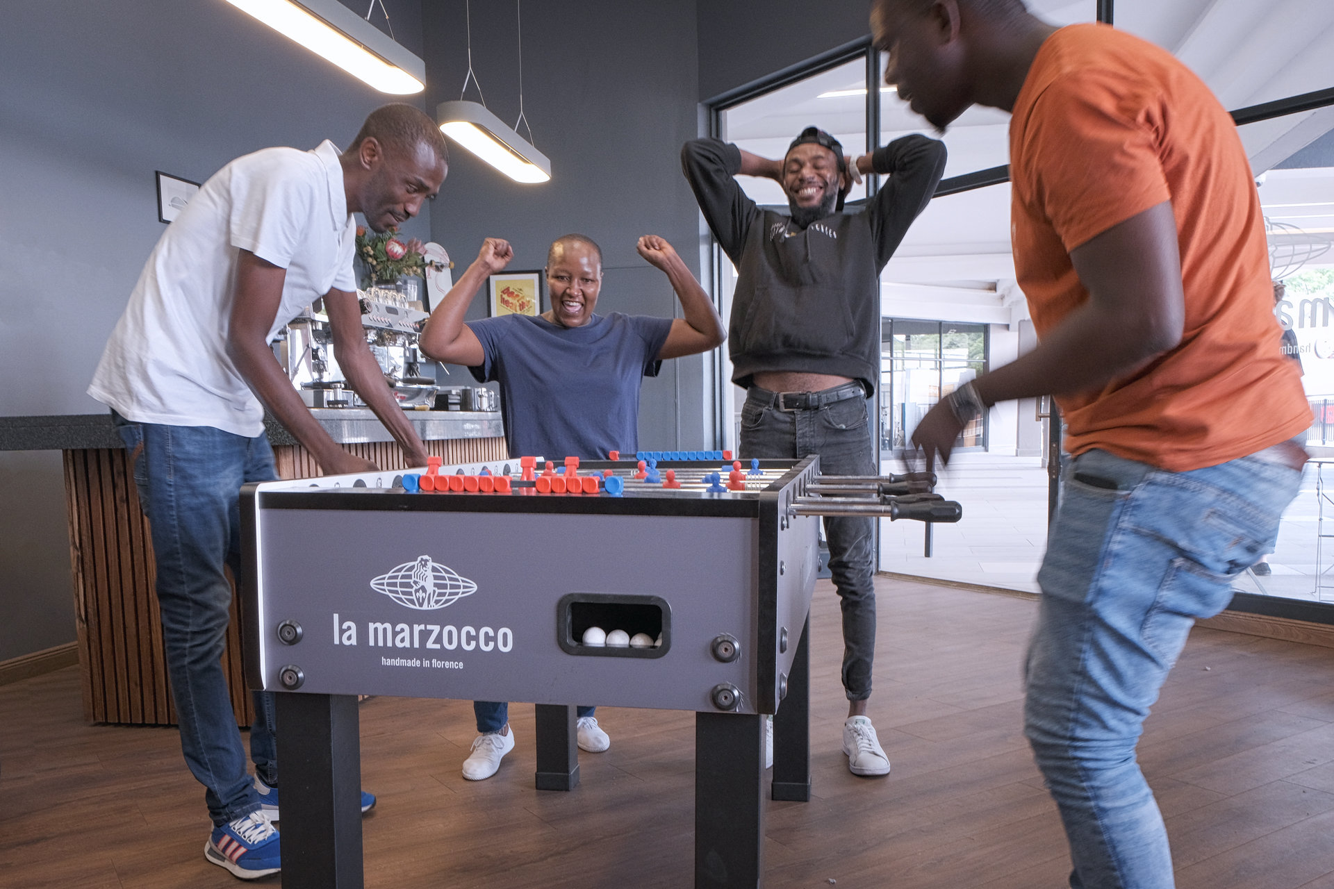 The team of baristas and manager playing foosball